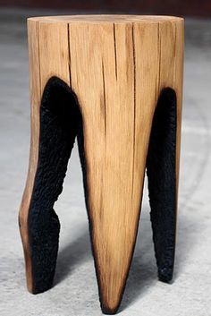 a wooden stool that has been carved to look like an upside down tree stump with black legs