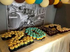 a table topped with lots of cupcakes covered in frosting