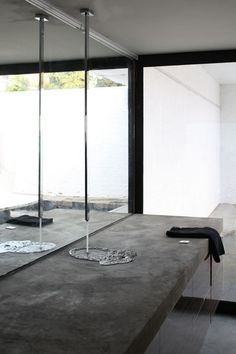 a bathroom with concrete counter tops and large windows