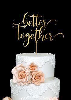 a white wedding cake with gold lettering and pink roses on top is the words, better together