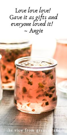 two jars filled with liquid sitting on top of a wooden table