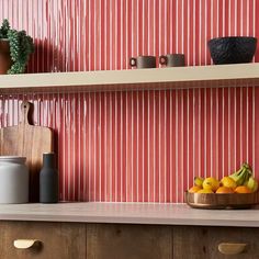 a bowl of fruit sitting on top of a wooden counter