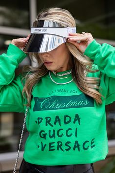 a woman wearing a green sweatshirt with the words prada gucci versace on it