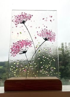 a glass vase with flowers in it on a window sill