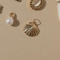 The timeless appeal of our Kai Shell Charm makes it a versatile accent for any curated necklace. Whether worn alone to showcase its coastal charm or paired with other charms for a personalized look, it adds a seaside touch to any ensemble. Gold plate 15mm Nickel- and lead-free Gold Coastal Jewelry Gift, Ocean-inspired Charms For Jewelry Making, Scallop Shells, Shells, Gold Plate, Gold