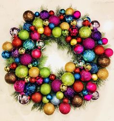 a wreath made up of christmas balls and pine needles