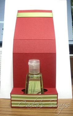 a bottle of cologne sitting on top of a desk next to a red and white box