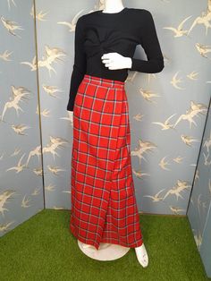 Fab tartan wrap skirt made in 1970s. In a red/ navy blue/ grey wool plaid, it`s maxi length , A-line shaped, with a slight flare at the back. It`s unlined and fastens with buttons at the waistband, with a zip concealed behind the front overlap. It comes with a silver coloured kilt pin. It`s handmade/ bespoke so has no labels, but is very nicely made. Measures 25" waist, hips approx. 38". Length 43" from top of waistband to hem. It has a tiny hole close to the hem, but is otherwise in excellent v Tartan Skirt, Kilt Pin, Red Maxi, Wool Plaid, Kilt, Wrap Skirt, Vintage 70s, Tartan, Blue Grey