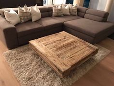 a living room with a large couch and wooden coffee table