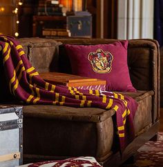 a harry potter throw blanket is sitting on a couch in front of a bookcase