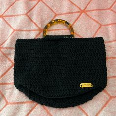 a black crocheted purse sitting on top of a bed