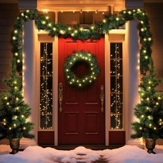 a red door decorated with christmas lights and wreath