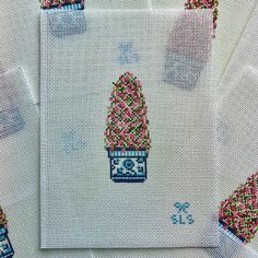 three cross stitch designs on white paper with pink and blue beads in the shape of a hot air balloon