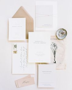 the wedding stationery is laid out on top of each other, including envelopes and cards