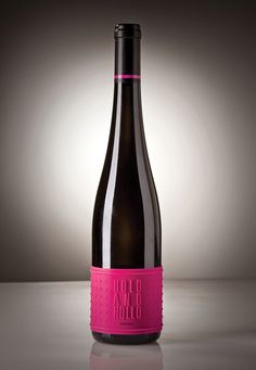 a bottle of wine with a pink label on it sitting in front of a gray background