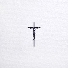 a black and white photo of a crucifix in the snow, taken from above