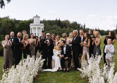 a group of people posing for a photo in front of a gazebo with flowers