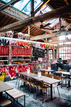 the interior of a restaurant with graffiti on the walls and tables in front of it