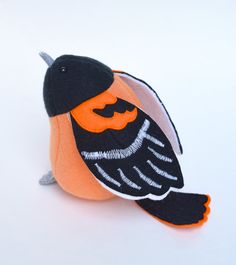 an orange and black bird sitting on top of a white table