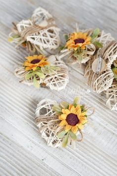 small sunflowers are tied to twine and placed on a wooden table top