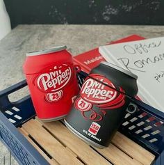 two cans of pepsi pop are sitting on a crate