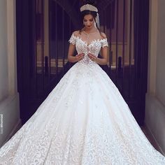 a woman standing in front of a doorway wearing a white wedding dress and tiara