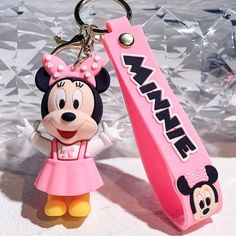 a minnie mouse keychain with a pink toothbrush on it's side