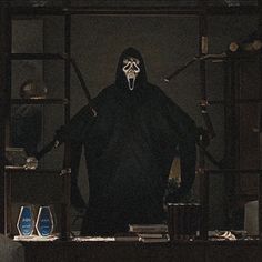 a man in a dark room wearing a mask and holding two swords