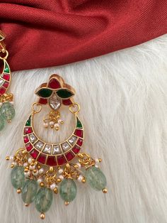 Jadau Kundan ChandbaI Earrings screwback earringsColor : GoldenSize : Length : 2 Inches; Weight : 9 grams eachStones : Red Green Jadau Kundan Pearls Green Beads Jadau Earrings, Green Beads, Social Events, Green Bead, Indian Jewelry, Red Green, Beads, Stone, Green