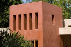 Orange earth tone stucco adobe modern LA home with ribbon, portal & cutout windows, in Mandeville Canyon Brentwood Los Angeles. La Home Exterior, House In California, Stem School, 90s Aesthetics, Brick Cladding, Memphis Milano