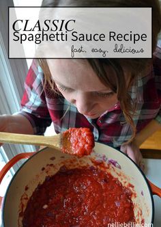 a woman holding a ladle full of red sauce