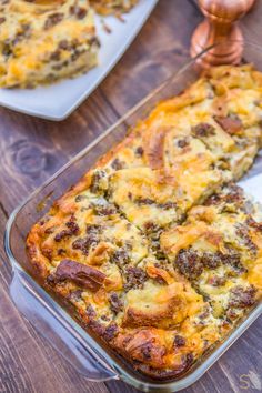 a casserole dish with meat and cheese in it sitting on a wooden table