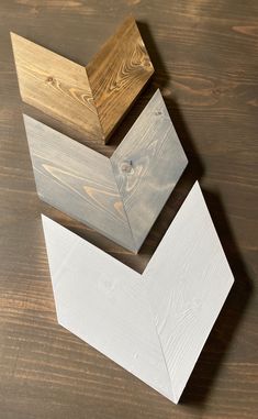 three pieces of wood are stacked on top of each other, one is white and the other is brown