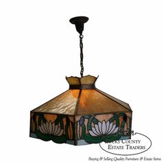 a stained glass lamp hanging from a chain with the words east county estate trades on it