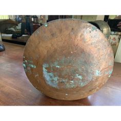 a large metal bowl sitting on top of a wooden table