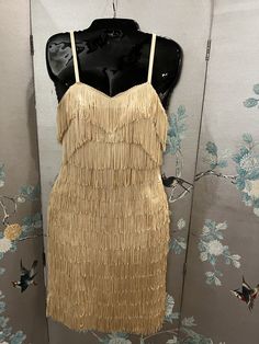 "1960's ode to 1920's, champagne colored, heavy, satin dress; studded with rows of rhinestones and layered over with silk fringe. This is a spectacular, spaghetti strap, party dress; made for dancing! Size 6-8, bust 33\"-34\", waist 26\" top of the dress where straps begin to hem 33\". Dry clean only" Cocktail Flapper Dress With Fringe, Summer Gatsby Style Flapper Dress With Fringe, Glamorous Fringe Dress With Spaghetti Straps, Flapper Dress With Fringe For Party, Glamorous Fringe Flapper Dress For Wedding, Gold Gatsby Flapper Dress For Summer, Evening Dress With Fringe And Spaghetti Straps, Fringe Spaghetti Strap Evening Dress, Spaghetti Strap Evening Dress With Fringe