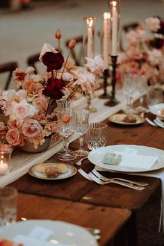 the table is set with flowers and candles