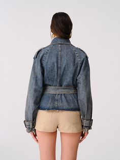 Step into a realm of timeless elegance with the Reckless Cropped Fit Denim Trench Coat. Made from 100% organic cotton, this coat combines sustainability with style, offering a chic cropped fit that complements all body types. Featuring eye-catching epaulettes on the shoulders, practical pockets, and adjustable belt and buckle details on the waist and wrists, this piece is as functional as it is fashionable. FABRIC: -100% Organic cotton. Chic Denim Blue Cotton Denim Jacket, Chic Medium Wash Denim Outerwear For Summer, Chic Summer Outerwear Medium Wash, Chic Washed Cotton Denim Jacket, Summer Medium Wash Outerwear For Work, Chic Relaxed Fit Denim Blue Outerwear, Oversized Chic Denim Jacket In Cotton, Oversized Chic Cotton Denim Jacket, Chic Oversized Cotton Denim Jacket