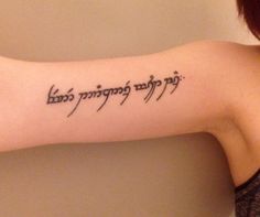 a woman with a tattoo on her arm that says, in many languages she is