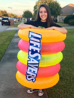 a woman standing in front of a stack of balloons with the words life savers on it