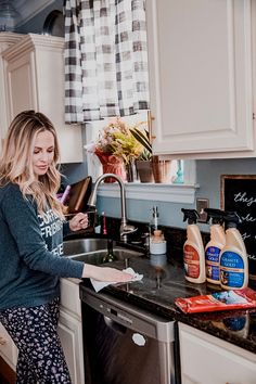 a woman standing in a kitchen next to a sink