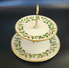 two plates with holly designs on them, one is holding a serving tray and the other has a fork