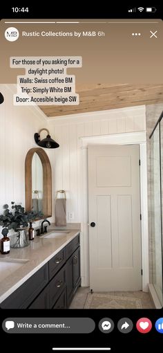 the bathroom is decorated in black and white with wood accents on the ceiling, along with a large mirror over the sink