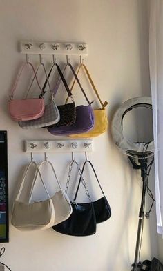 there are several purses hanging on the wall and one has a sign that says accessories to spice up an outfit