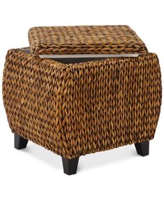 a brown wicker ottoman sitting on top of a wooden table