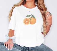 Brighten up your day with our Watercolour Orange Tee! Featuring a vibrant, artistic depiction of oranges, this T-shirt is perfect for those who love nature-inspired designs and a pop of colour. it offers both comfort and style, making it ideal for casual outings or relaxing at home. Whether you're a fruit lover or an art enthusiast, this refreshing tee is a delightful addition to any wardrobe. Please note that the adult t-shirts are Gildan branded. Fabric: Modern, fits perfectly. 100% Soft ring- Watercolour Orange, Sliced Orange, Orange Graphic Tee, Modern Fits, Orange Graphic, Art Enthusiast, Orange Tees, Orange T Shirt, Vintage Watercolor