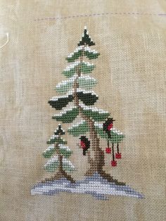 a cross stitch christmas tree with bells on it