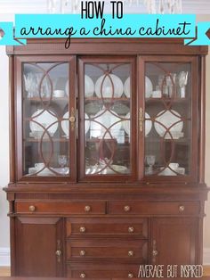 a china cabinet with glass doors and plates on top