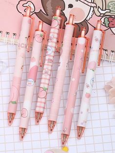 five pink and white pens sitting next to each other on a tile floor with an image of a teddy bear in the background