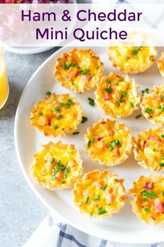 ham and cheddar mini quiche on a white plate next to orange juice